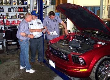 Image of Three Customer Checking Red Vehicle Engine